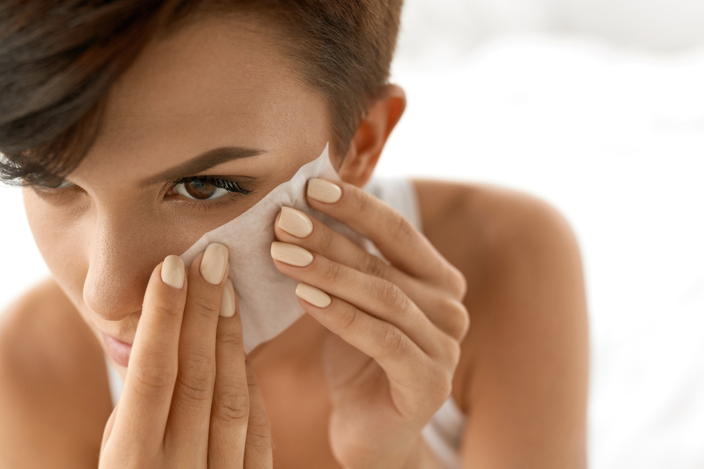 woman with face cleansing towelette